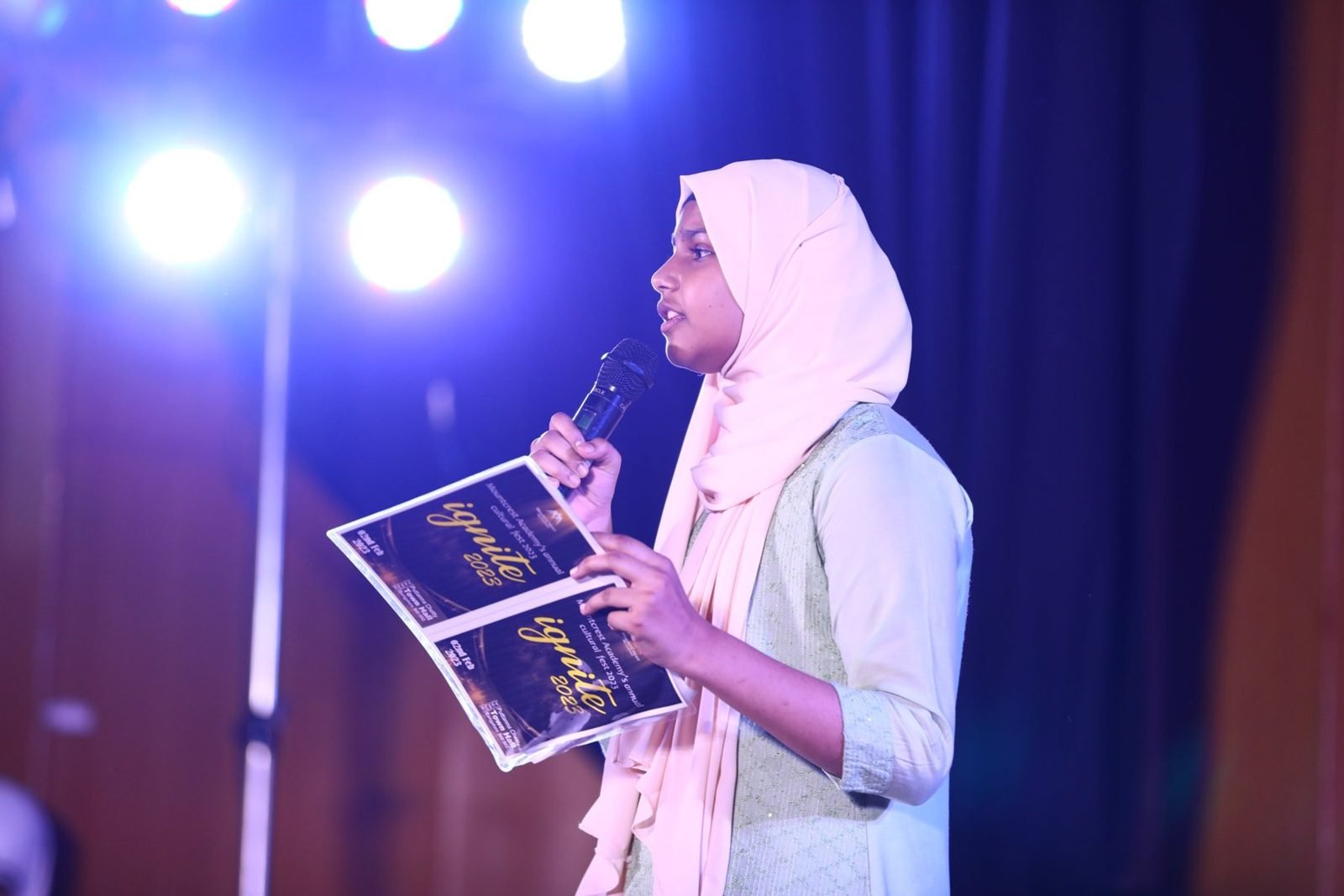 A Mountcrest student speaks into a microphone on stage